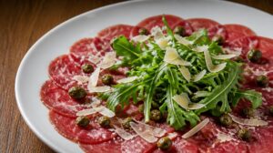Carpaccio z hovězí svíčkové s kapary, rukolou a hoblinami parmazánu